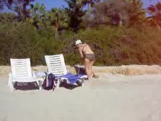 Dama zamiatająca piasek na plaży